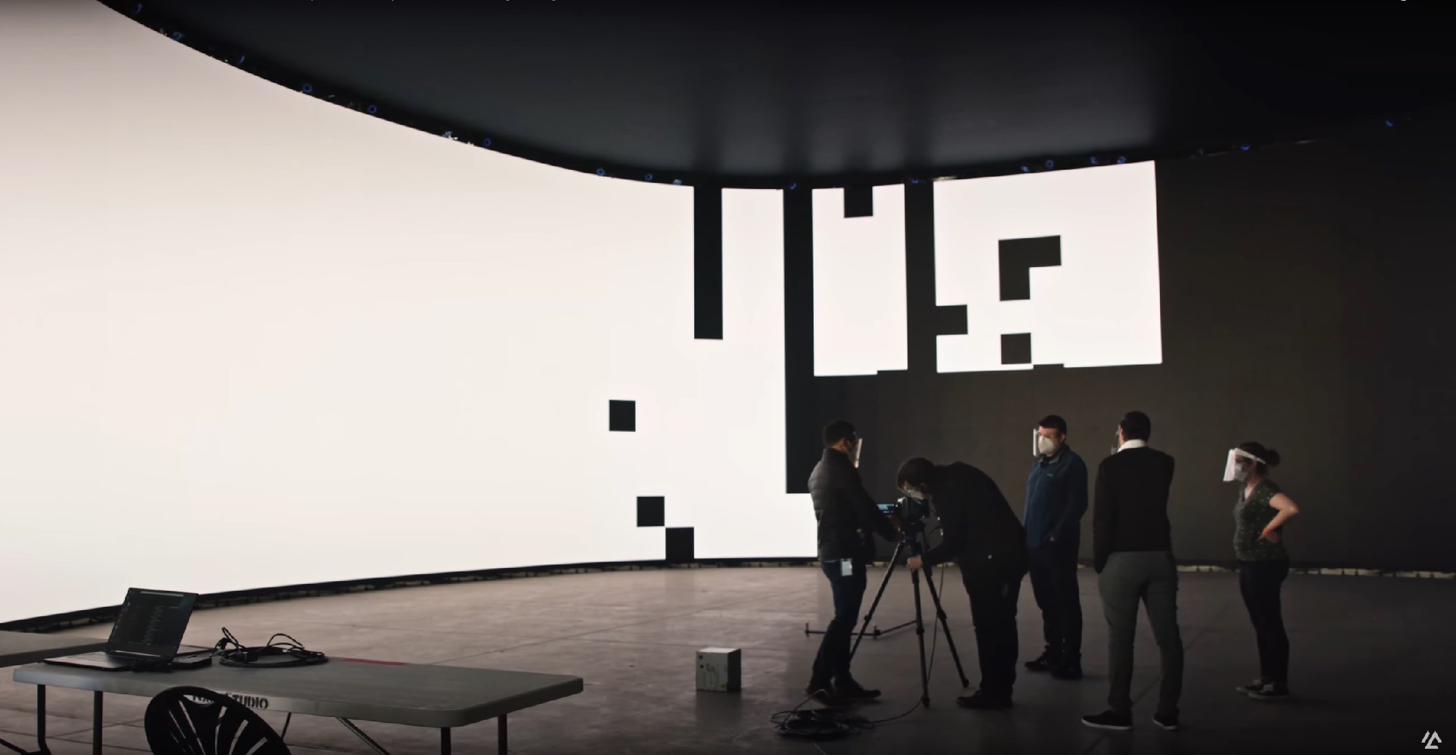 Equipo de rodaje trabajando en un estudio de producción virtual con pantallas LED